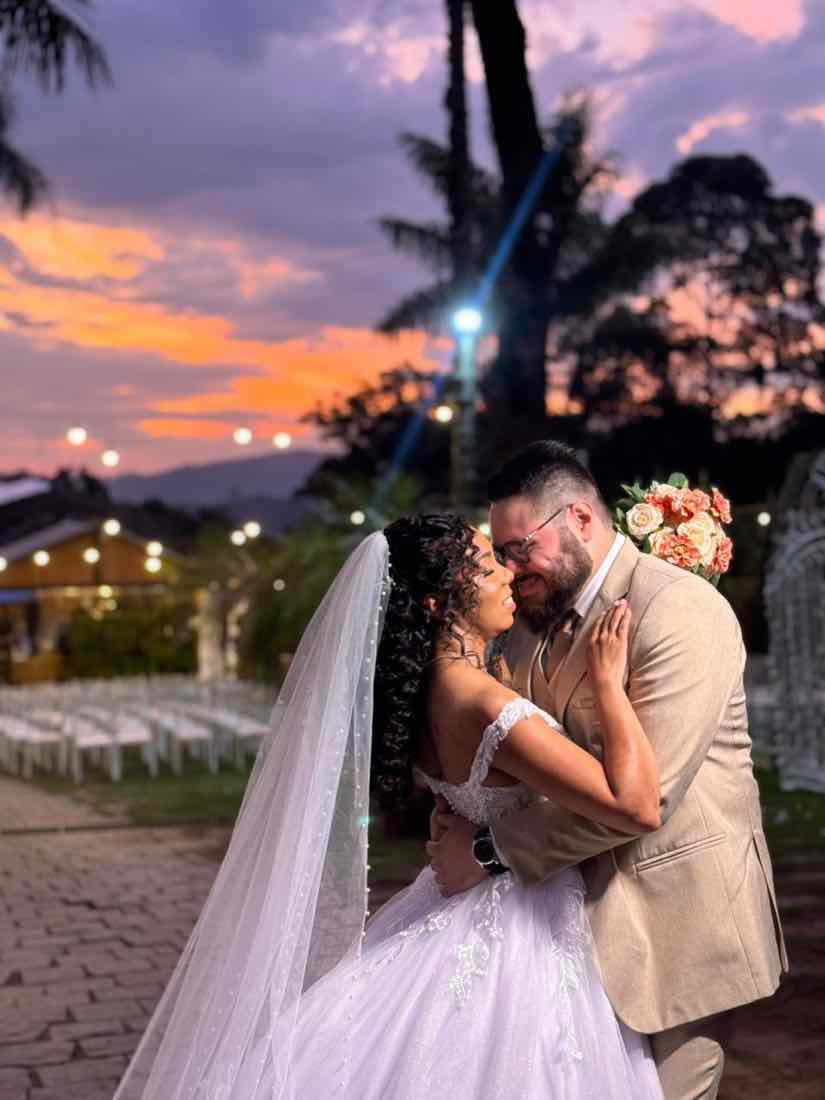 Casal abraçado com o pôr do sol ao fundo
