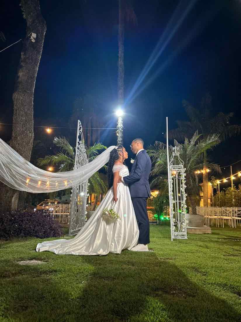 Noiva com véu ao vento no jardim à noite